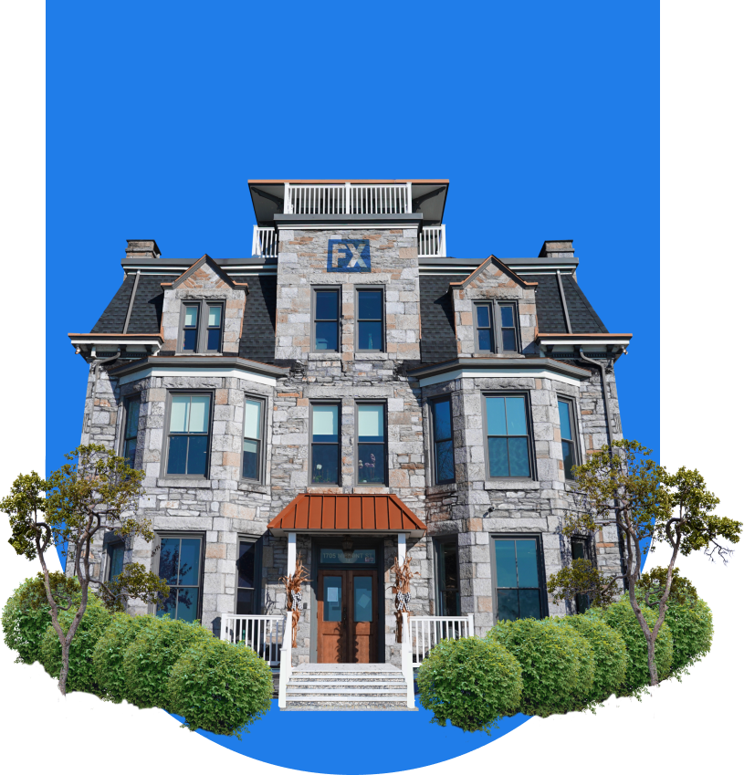 A three-story stone house with a mansard roof and rooftop deck, featuring a red awning over the front entrance, surrounded by greenery under a clear blue sky.