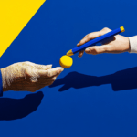 Two hands: one holds a yellow ball, the other a blue pencil.