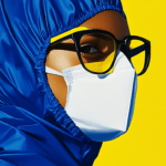 Person in blue protective gear, mask, and glasses.