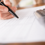 Woman calculating math on a piece of paper with a calculator