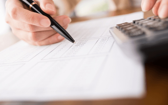 Woman calculating math on a piece of paper with a calculator