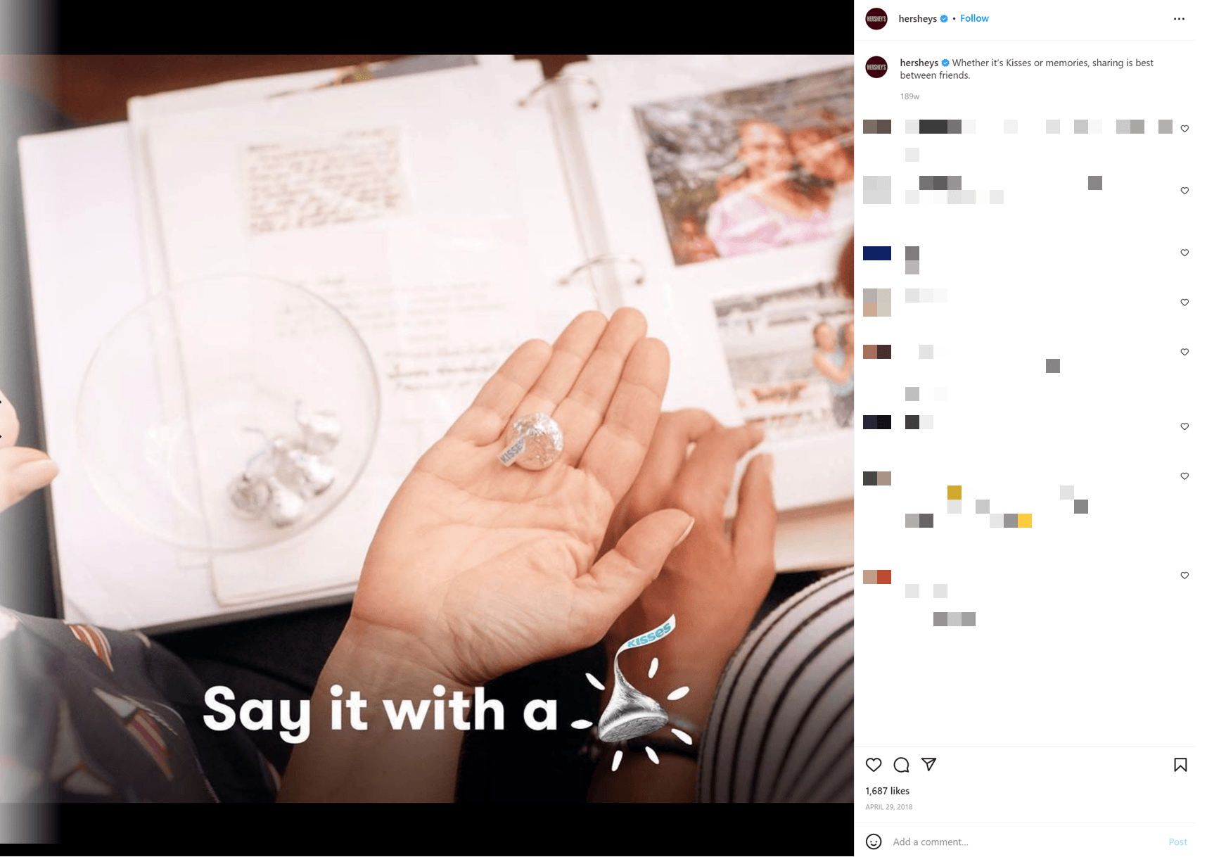 An Instagram post from Hershey featuring two people holding a Kiss in their hands while looking at a scrapbook