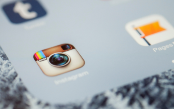 Close-up of a smartphone screen displaying the Instagram app icon among other app icons.