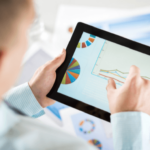 Man analyzing data charts on a tablet