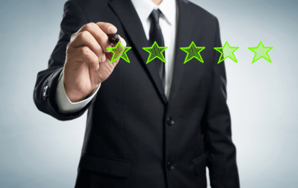 Person in a business suit adding a fifth star to a row of four green stars, indicating a five-star rating.