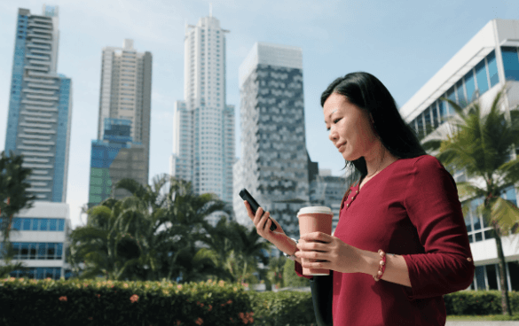 Woman browsing on her phone while standing outside