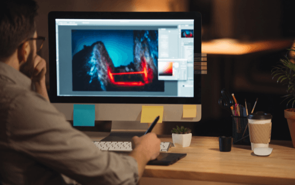 man working on a Mac computer designing a website