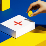 Hand holding coin over medical box