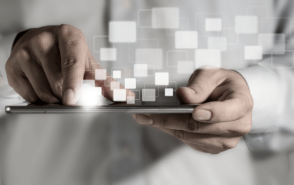 A person in a white shirt using a tablet with floating digital squares above the screen, symbolizing advanced technology interaction.