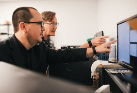 Employee pointing at screen at Net Friends