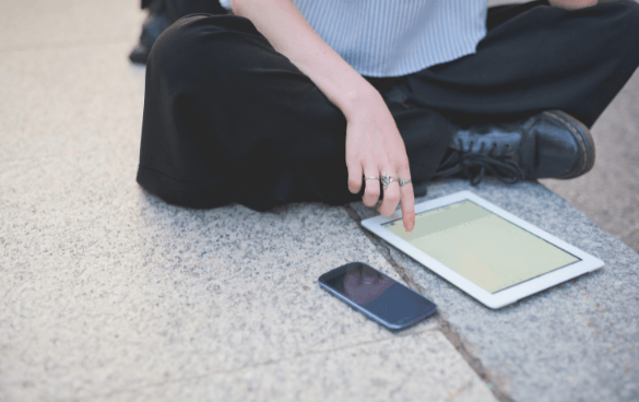 Woman scrolling through a tablet on the floor