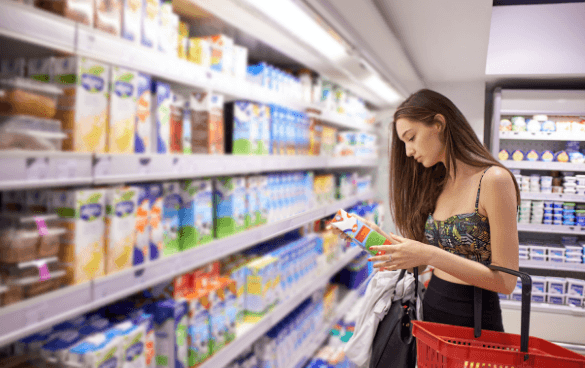 Woman shopping in the dairy aisle of a grocery store