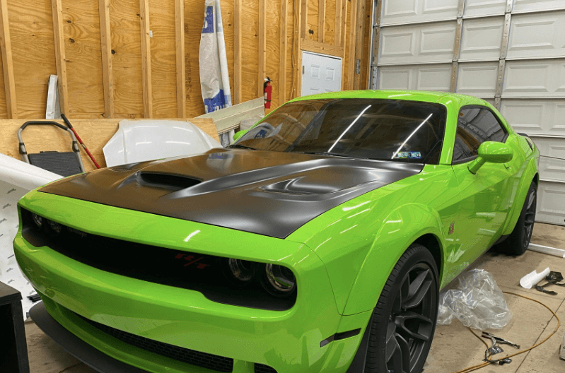 greed Dodge Challenger in a garage