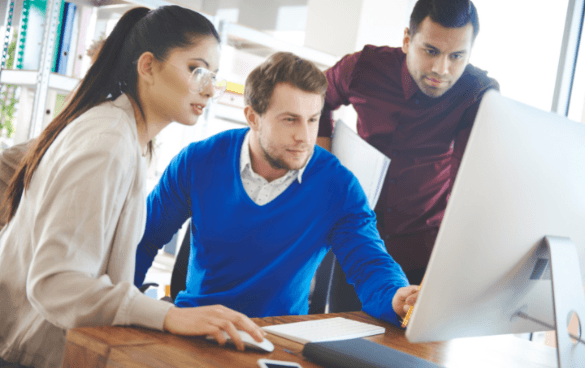 Group of people staring at a desktop computer