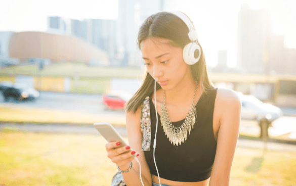 Woman scrolling through her phone while listening to music