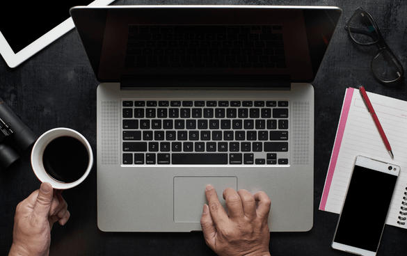 Person scrolling on a gray laptop