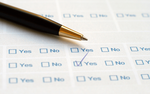 Close-up of a survey with 'Yes' and 'No' options, a pen pointing to a checked 'Yes' box.