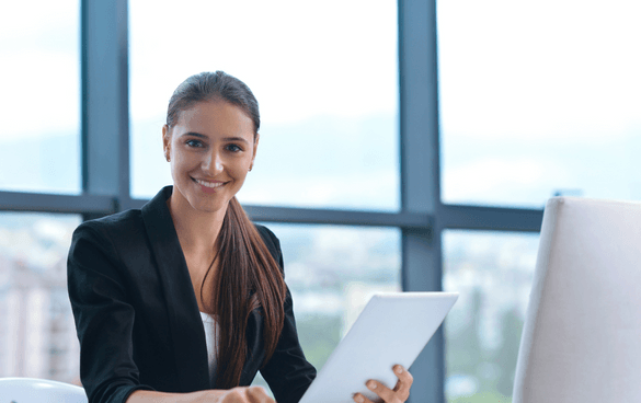 Woman in a business suit holding up papers and smiling at the camera