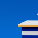 A stylized white human figure standing on a white platform on top of a large book with a blue cover, with a blue circular shape beneath the figure, against a blue background.