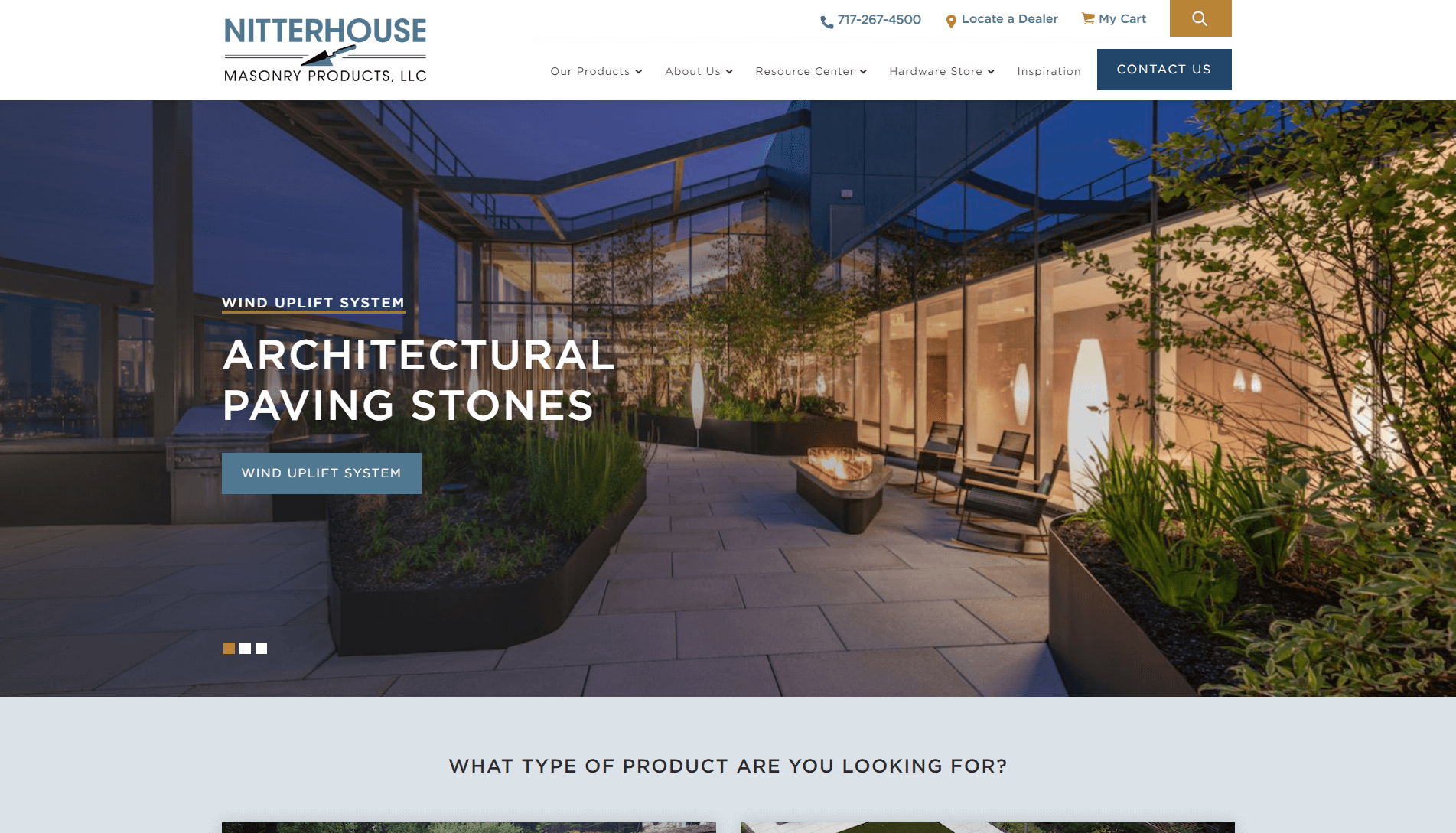 Modern outdoor terrace with architectural paving stones, contemporary furniture, and planters at dusk, part of Nitterhouse Masonry Products website.