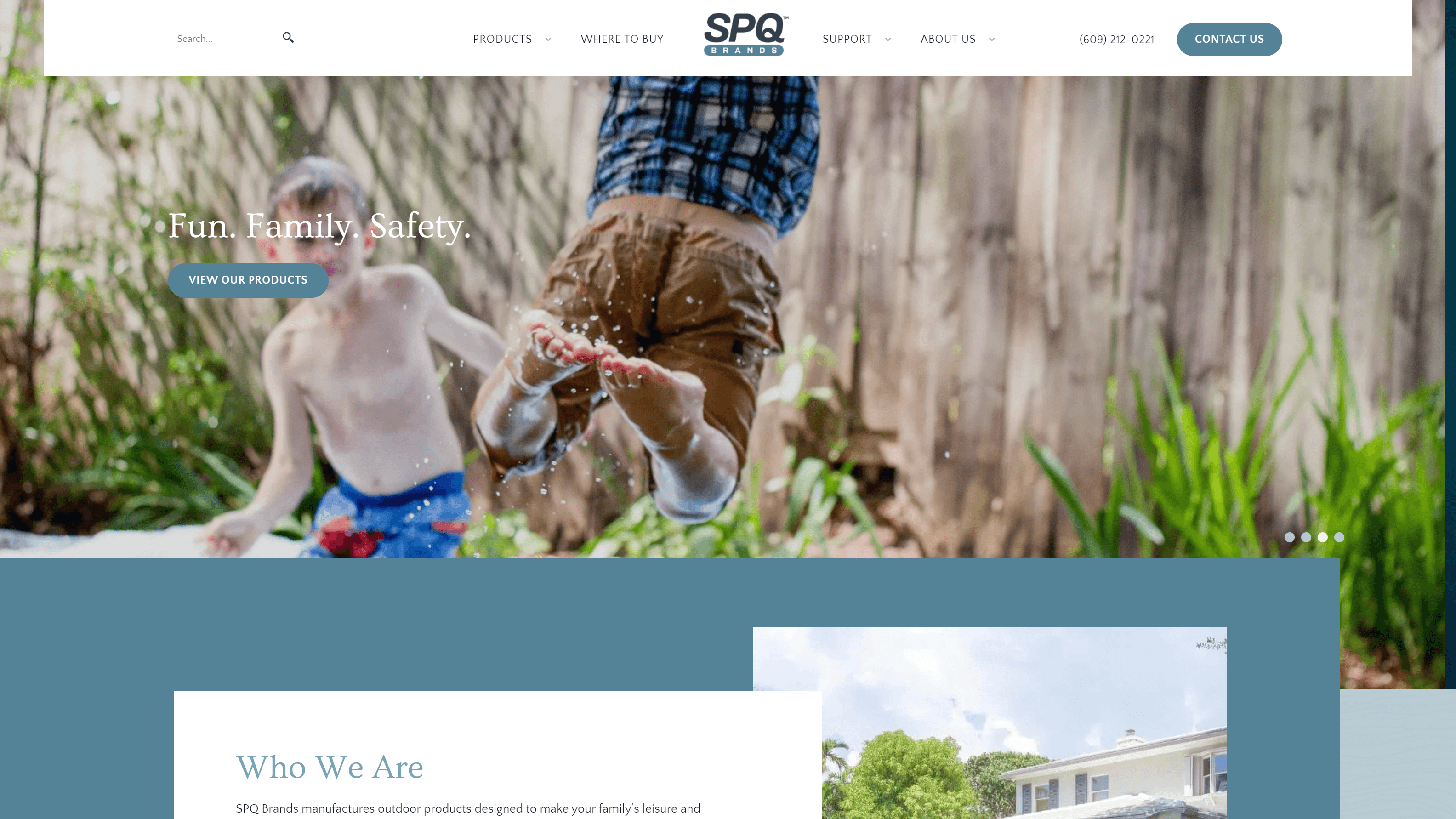 Child playing with water, mid-jump with water droplets around, wearing brown shorts and a blue checked shirt. Text reads 'Fun. Family. Safety.' with a 'VIEW OUR PRODUCTS' button. Website navigation and company information for SPQ Brands are also visible.