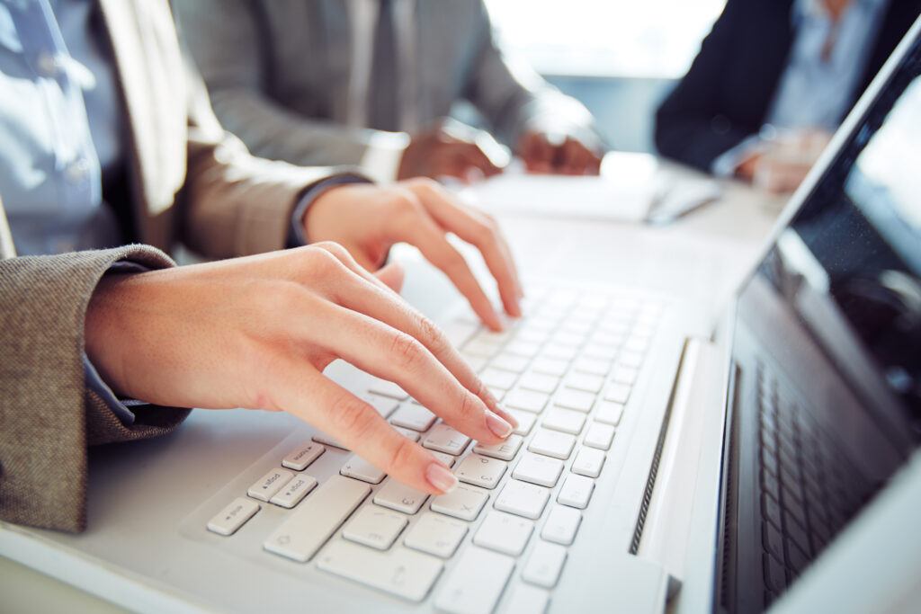 Hands of businesswoman typing on laptop