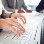 Hands of businesswoman typing on laptop