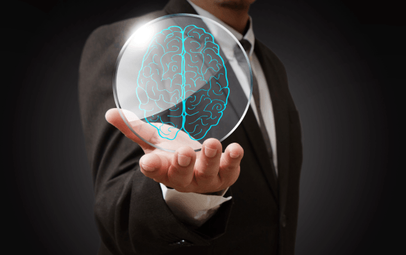 Person in a suit holding a holographic brain representation in their palm.