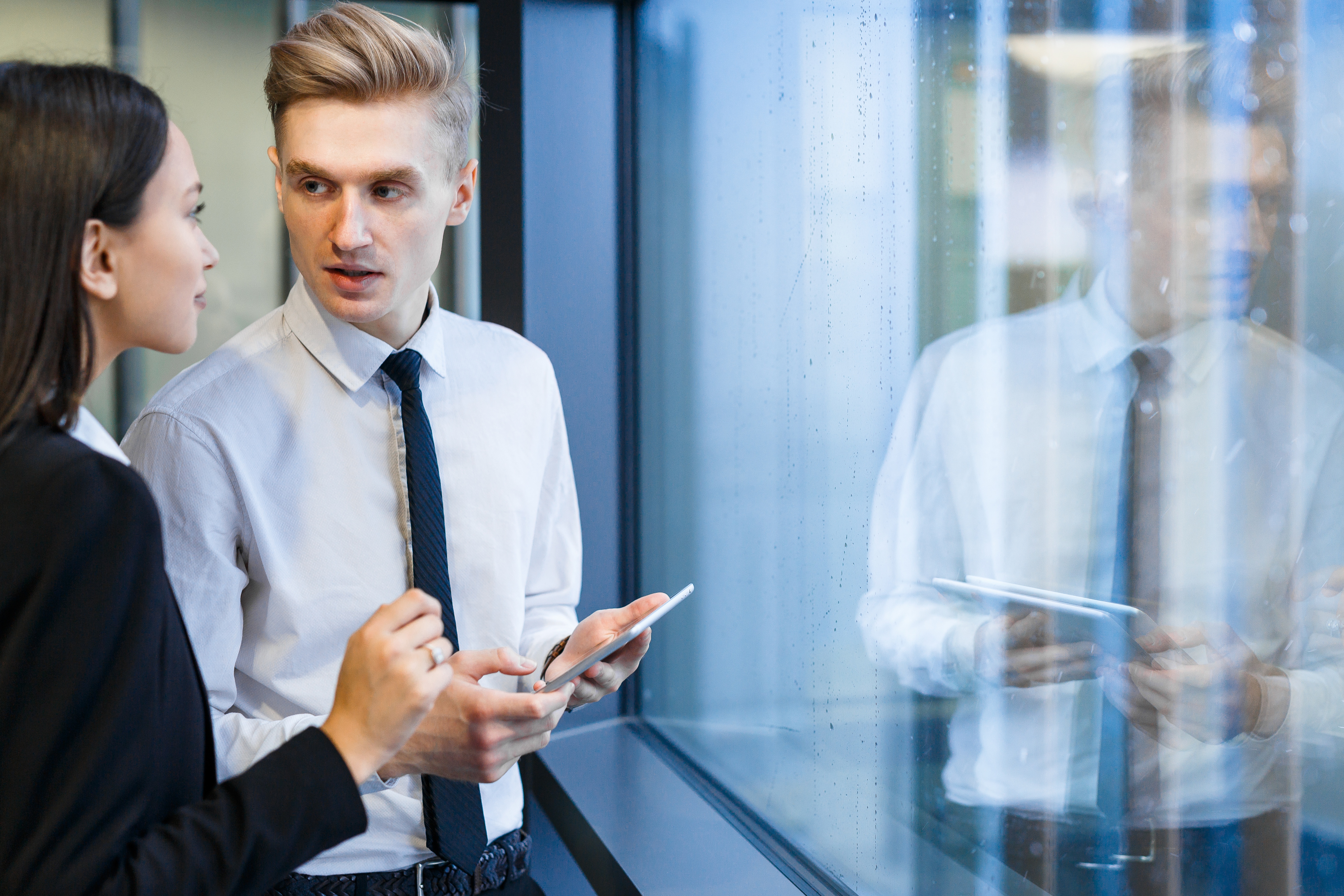 Two young employees discussing situation on financial market