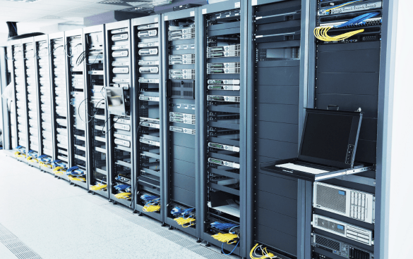 Server racks with network equipment and a mounted laptop in a data center.