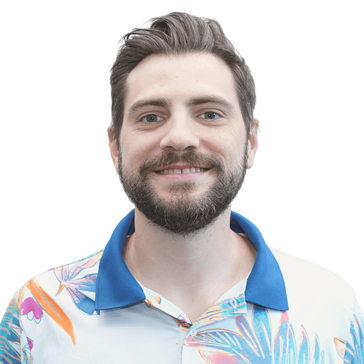 A smiling man with a beard and mustache, wearing a casual collared shirt with a floral pattern.