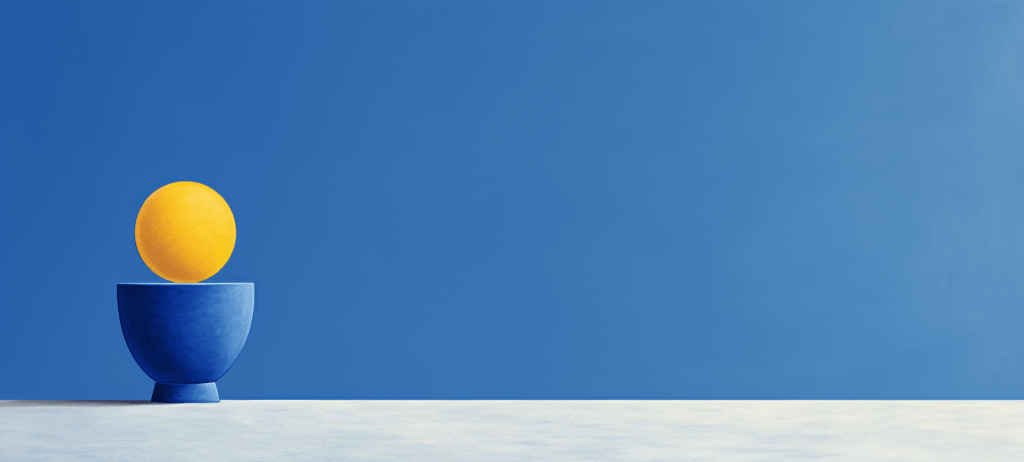 A bright yellow sphere resting on a deep blue bowl, centered against a matching blue background with a white textured surface beneath.