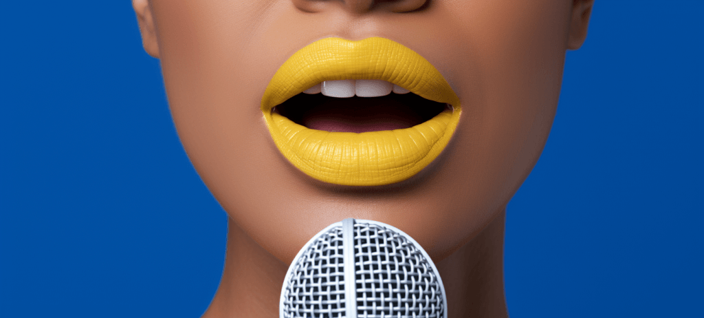 Close-up of a person's lower face with bright yellow lipstick, slightly parted lips, and a microphone in front.