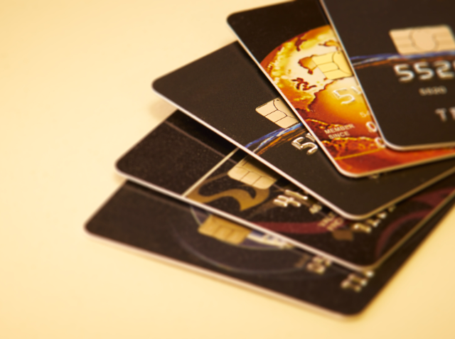 A close-up of a stack of credit cards fanned out on a light surface.