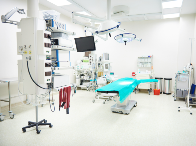 A modern, well-equipped operating room with an operating table, surgical lights, and various medical devices and monitors.