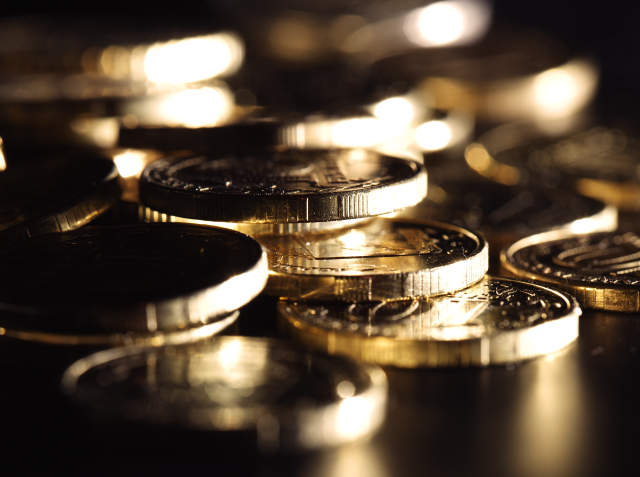 Close-up of various shimmering coins with a shallow depth of field.