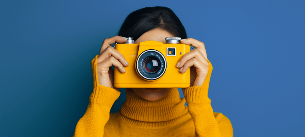 woman holding a yellow camera in front of her face