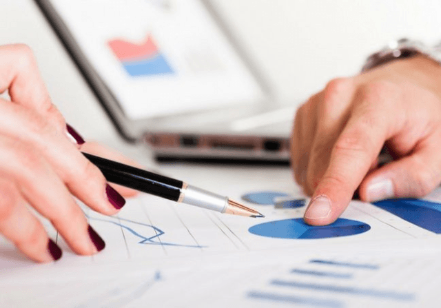 Financial insurance meeting with fingers pointing at graphs