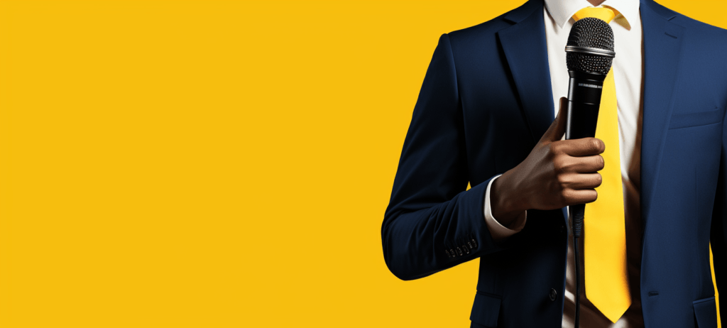 Man in a suit talking into a microphone