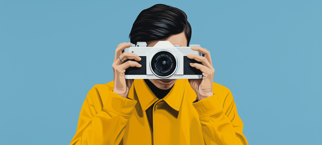 Man in a yellow shirt holding up a camera to his face