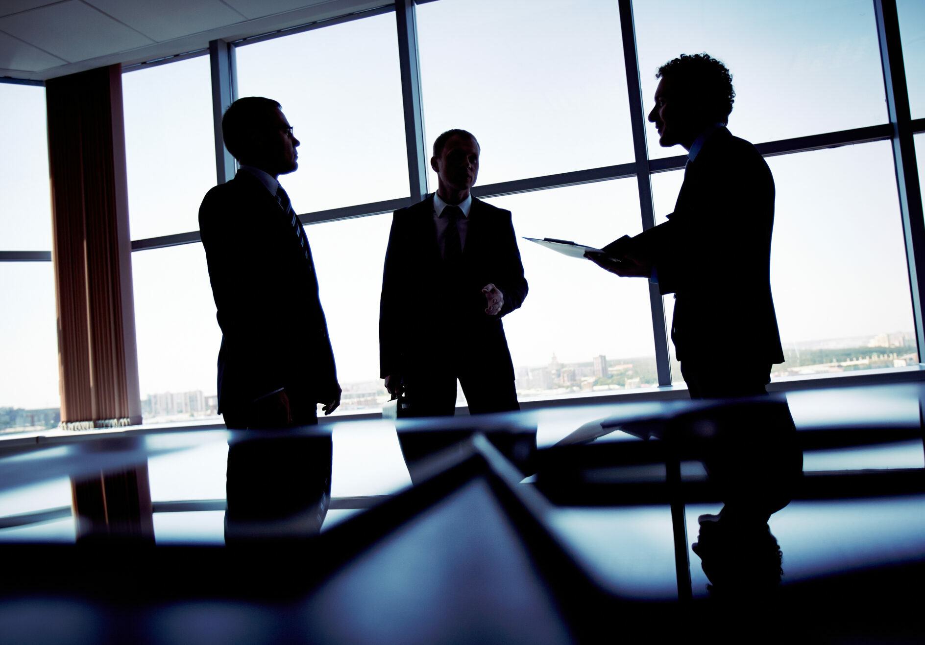 men in suits standing around discussing