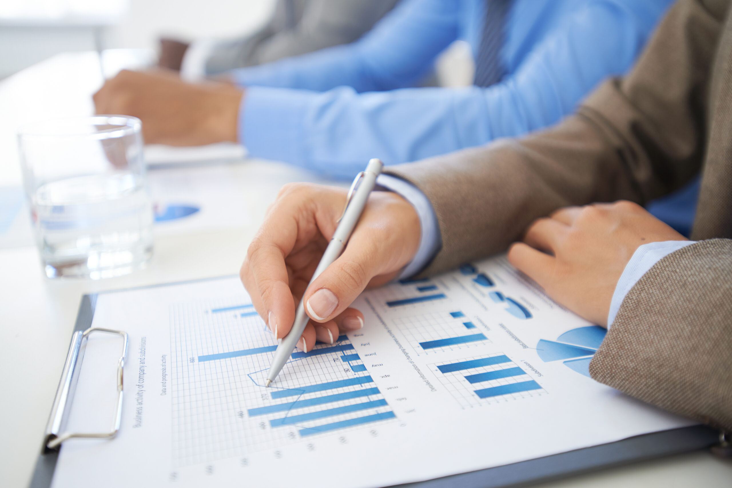 Woman in a business suit writing on a paper with charts