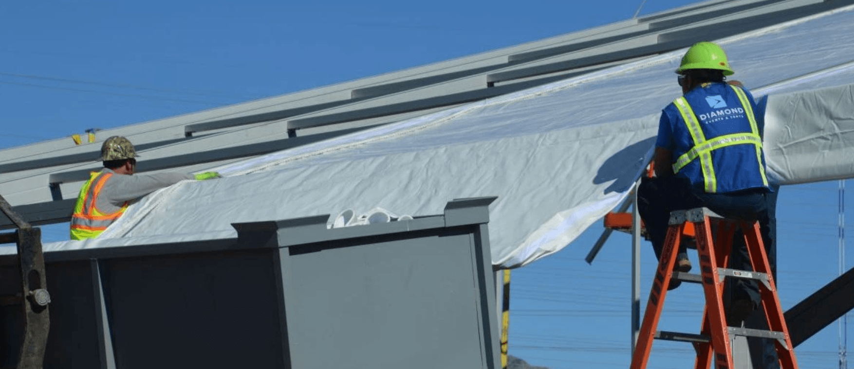 Man on a ladder putting up a tent