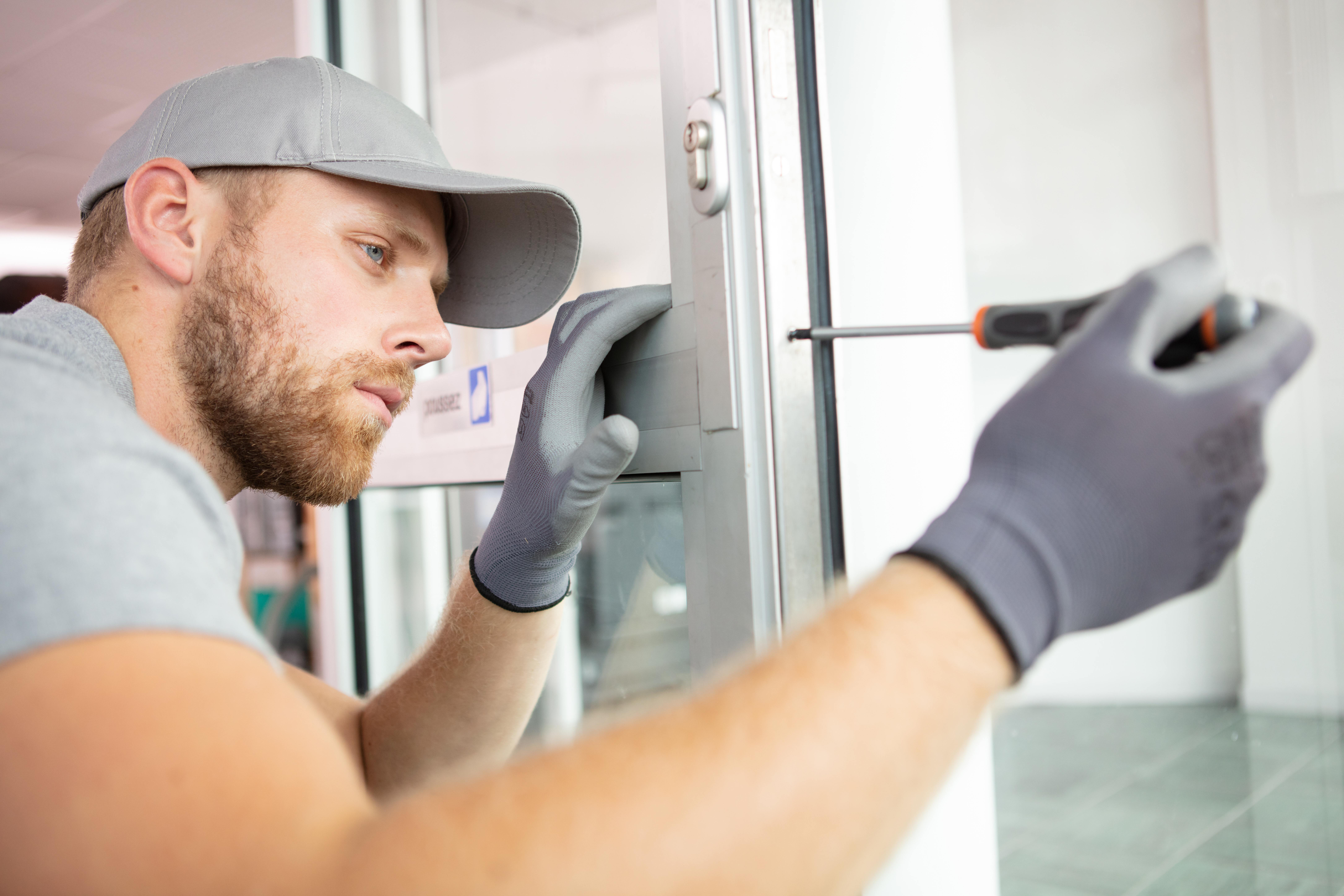 cheerful locksmith installing a door lock