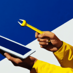 A person holding a wrench to a tablet