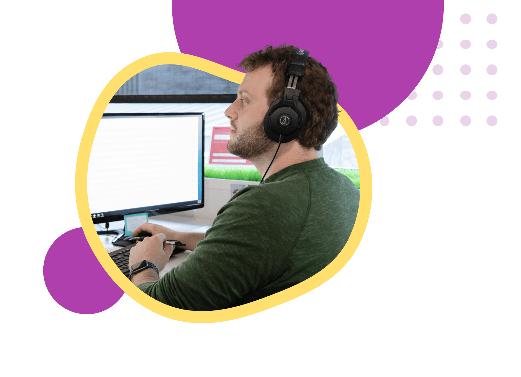 Person wearing headphones sitting at desk with computer displaying white screen